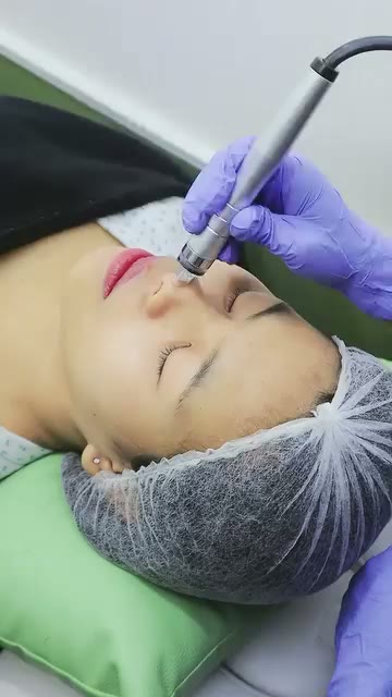 A Q Skin therapist performing a machine-powered facial